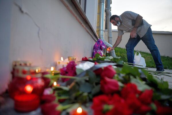 مردی در یادبود قربانیان این انفجار در سفارت لبنان در مسکو گل می گذارد - اسپوتنیک ایران  