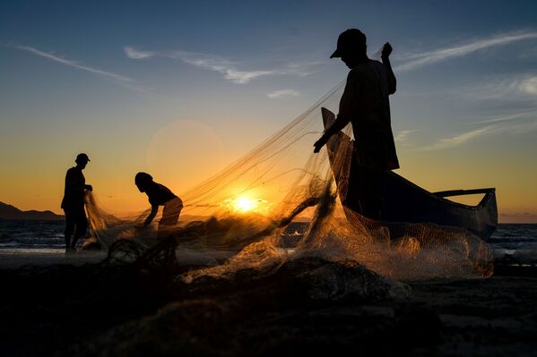 ماهیگیران بعد از ماهیگیری در غروب آفتاب در باندا آچه، سوماترا، اندونزی، تورهای خود را تمیز می کنند. - اسپوتنیک ایران  