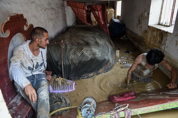 پاکسازی خانه پس از وقوع سیل در افغانستان - اسپوتنیک ایران  