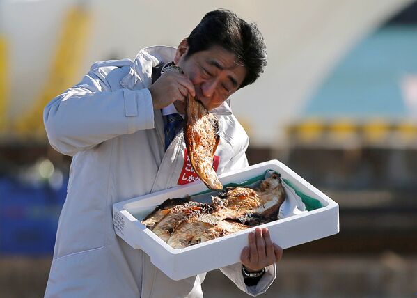 نخست وزیر ژاپن شینزو آبه، ماهی سرخ شده محلی را در بندر سوما هاراگاما می خورد - اسپوتنیک ایران  