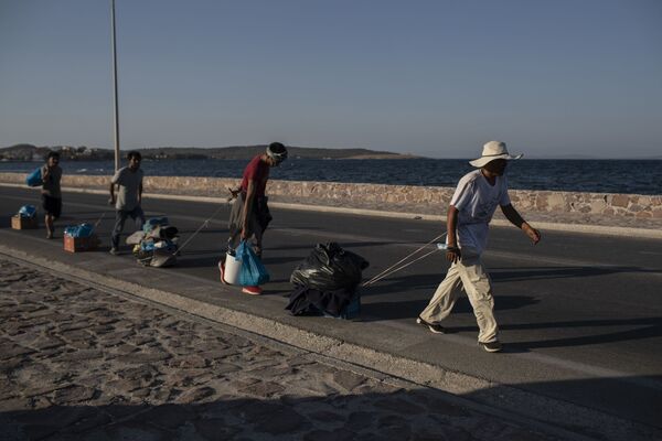 مهاجران با وسایل در جاده نزدیک شهر میتیلین در جزیره لسوس، یونان - اسپوتنیک ایران  