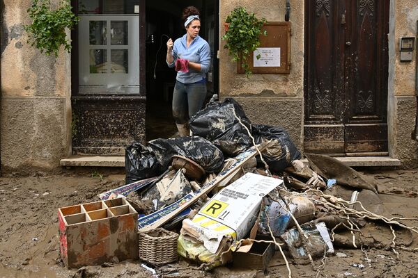 یک زن پس از رانش زمین در گارسیو خانه خود را تمیز می کند، پیمونت - اسپوتنیک ایران  