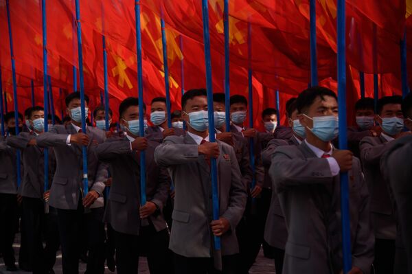 راهپیمایی چندین هزار نفره با ماسک در میدان کیم ایل سونگ در پیونگ یانگ به مناسبت آغاز کمپین ۸۰ روزه برای حمایت از هشتمین کنگره حزب کارگر کره که در ژانویه ۲۰۲۱ برگزار می شود.    - اسپوتنیک ایران  