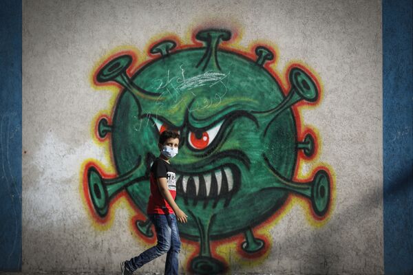 پسری در کنار گرافیتی ویروس کرونا در غزه فلسطین - اسپوتنیک ایران  