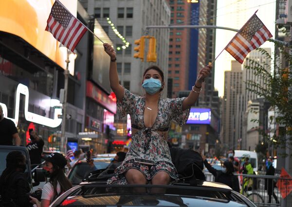 دختری در یکی از خیابان های نیویورک در حال شادی برای پیروزی جو بایدن در انتخابات ریاست جمهوری - اسپوتنیک ایران  