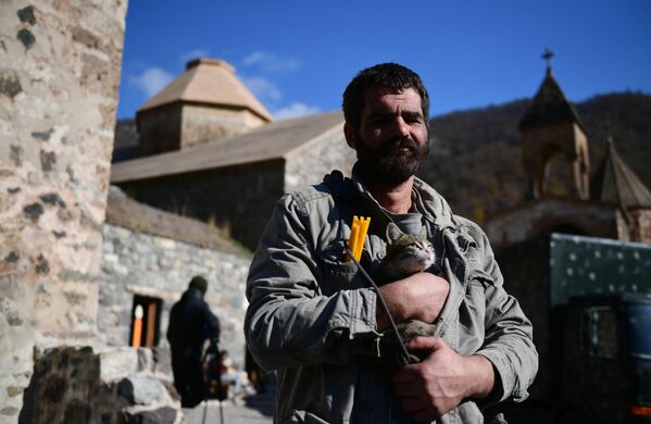 مردی که گربه ای را در نزدیکی معبدی در صومعه دادیوانک قره باغ در آغوش خود نگه داشته است - اسپوتنیک ایران  