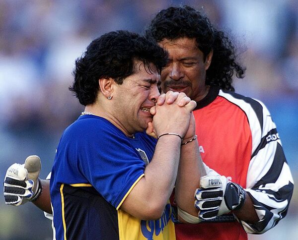 دروازه بان کلمبیایی رنه ایگوییت در حال آرام کردن مارادونا در مراسمی به افتخارش - اسپوتنیک ایران  