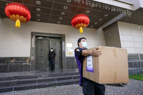 کارمند FedEx جعبه ای را از سفارت چین در هیستون می برد - اسپوتنیک ایران  