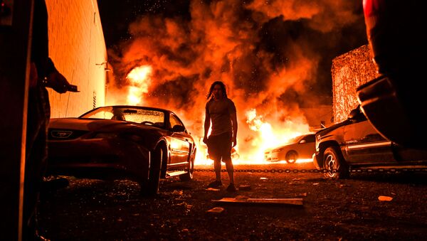 اتومبیل در حال سوختن در پی آشوب‌های به وجود آمده پس از قتل جورج فلوید به دست پلیس در مینیاپولیس، ایالات متحده آمریکا - اسپوتنیک ایران  