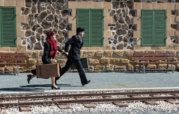 دختر و پسری با چمدان های قدیمی در حال دویدن به سمت قطار - اسپوتنیک ایران  