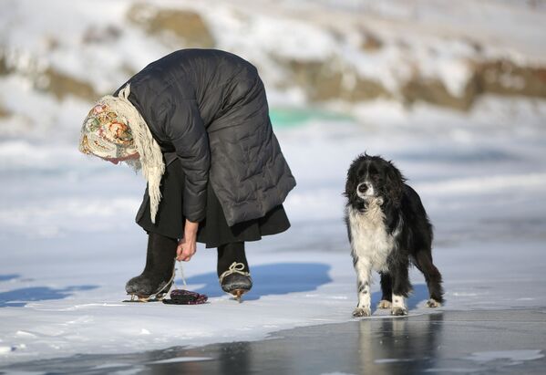 لیوبوف مورخودوا ۷۹ ساله اهل روستایی در استان ایرکوتسک روسیه با سگش در حال پوشیدن کفش های اسکیت  
 - اسپوتنیک ایران  