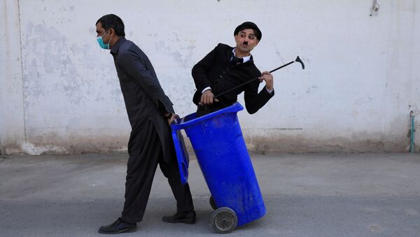 Мужчина в костюме Чарли Чаплина в мусорном баке во время представления в Пешаваре, Пакистан - اسپوتنیک ایران  