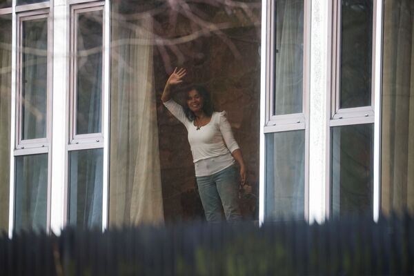 زنی از پنجره هتل رادیسون بلو دست تکان می دهد - اسپوتنیک ایران  