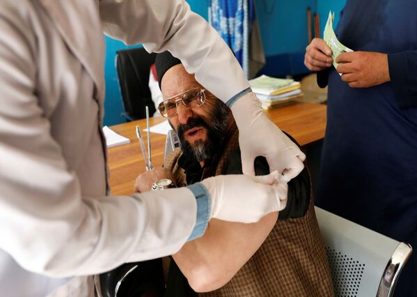 کارمند بیمارستان در حال تزریق واکسن آسترازنکا در کابل افغانستان - اسپوتنیک ایران  