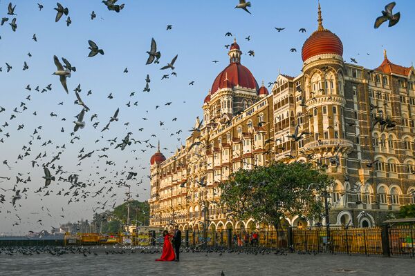 یک زن و شوهر در تاریخ 4 مارس 2021 در مقابل هتل تاج محل در بمبئی عکس می گیرند. - اسپوتنیک ایران  