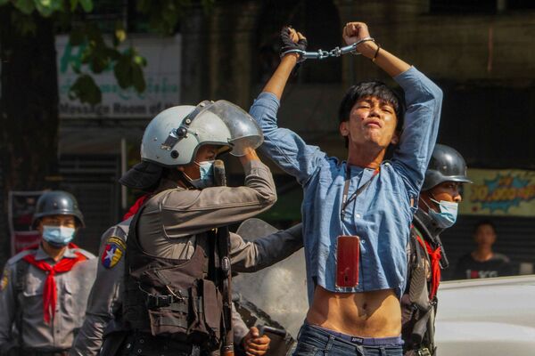 یک معترض که در هنگام تجمع علیه کودتای نظامی در یانگون، میانمار توسط افسران پلیس بازداشت شد. - اسپوتنیک ایران  