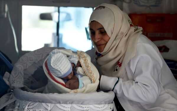 پرستار با دوقلوهای تازه متولد شده در آمبولانس در فرودگاه یمن - اسپوتنیک ایران  