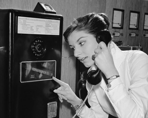 دختر آلمانی در حال استفاده از تلفن با ارتباط بین المللی در سال ۱۹۵۷ - اسپوتنیک ایران  