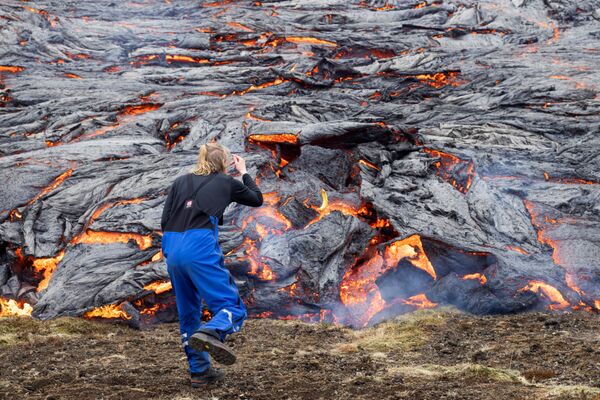 مردی به زبانه های آتشفشان در ایسلند نگاه می کند  - اسپوتنیک ایران  