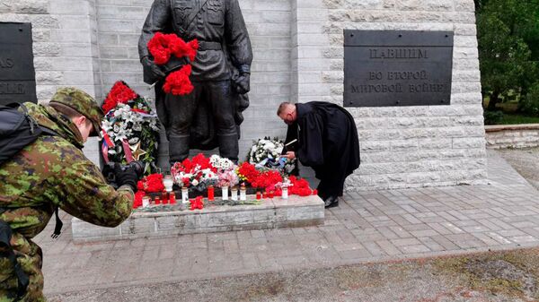 تقدیم تاج گل توسط روحانی نیروهای دفاعی استونی به یادبود جانباختگان در جنگ جهانی دوم در قبرستان نظامی تالین  - اسپوتنیک ایران  