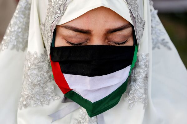 زن مسلمان با ماسک پرچم فلسطین در هنگام نماز عید فطر - اندونزی
 - اسپوتنیک ایران  