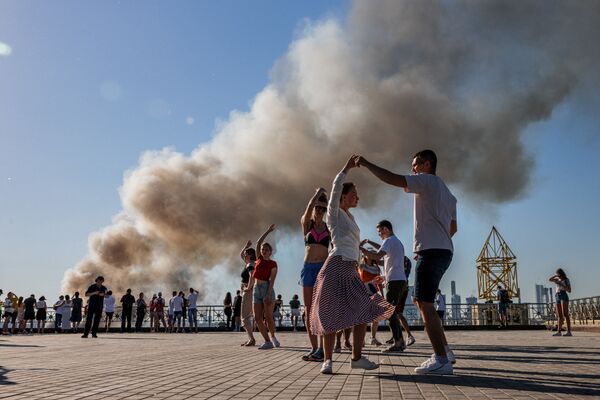 رویدادهای هفته به روایت تصویر 
رقص سامبا در زمینه دودی که از آتش سوزی انباری در مسکو بلند شده است - اسپوتنیک ایران  