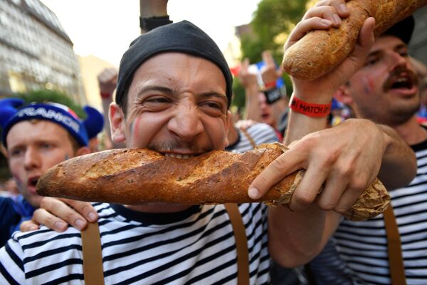 طرفدار فوتبال در فرانسه و خوردن یک نان باگت به عنوان نماد فرانسه - اسپوتنیک ایران  