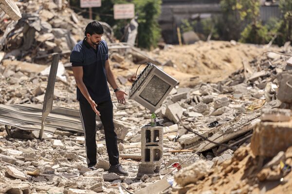 هنرمند فلسطینی در حال نمایش خانه های خراب شده طی حملات اسرائیل در غزه - اسپوتنیک ایران  
