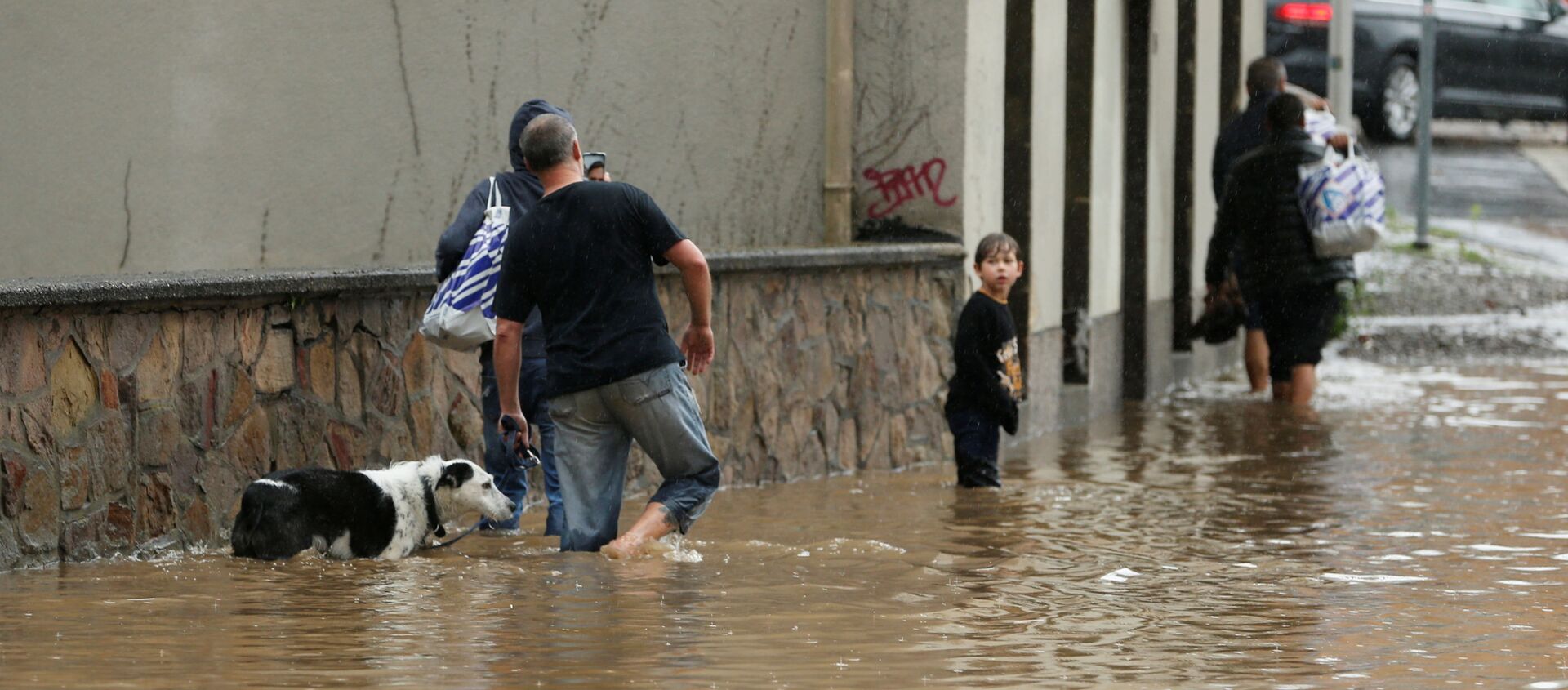 Люди идут по затопленной улице после проливных дождей в Хагене, Германия - اسپوتنیک ایران  , 1920, 16.07.2021