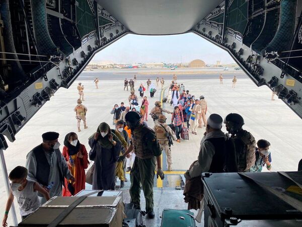 شهروندان اسپانیایی و افغانستانی در حین سوار شدن به هواپیمای نظامی در فرودگاه بین المللی حامد کرزی در کابل  - اسپوتنیک ایران  