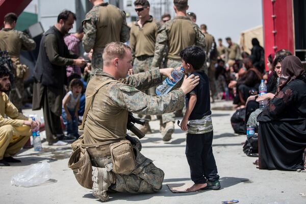 تخلیه کودکان از افغانستان
سرباز آمریکایی با کودکان افغانی در فرودگاه کابل - اسپوتنیک ایران  