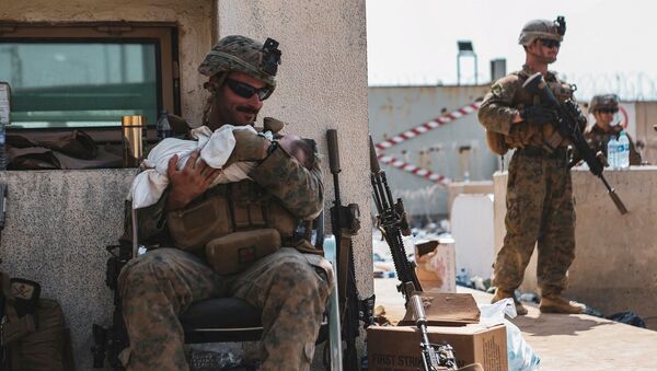 Американский солдат с младенцем в аэропорту Кабула  - اسپوتنیک ایران  