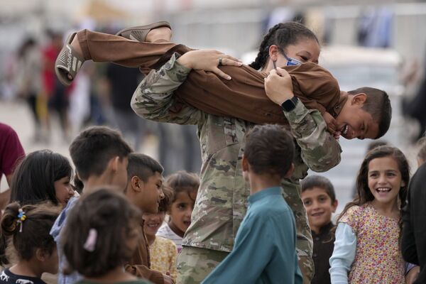 سرباز آمریکایی با کودکان پناهجوی  افغان در پایگاه هوایی رامشتاین در آلمان بازی می کند - اسپوتنیک ایران  