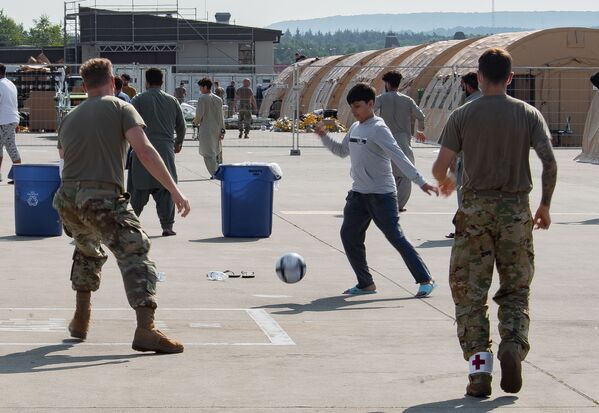 خلبانان نیروی هوایی آمریکا با کودکان پناهجوی  افغان در پایگاه هوایی رامشتاین در آلمان فوتبال بازی می کنند - اسپوتنیک ایران  