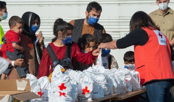 نمایندگان صلیب سرخ در میان پناهپویان افغان در پایگاه هوایی رامشتاین در آلمان کمک های اانسانی توزیع می کنند - اسپوتنیک ایران  