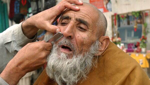 آرایشگر خیابانی در جلال آباد سال ۲۰۰۶ مشتری خود را اصلاح می کند - اسپوتنیک ایران  