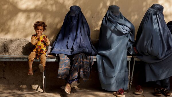 کودکی در کنار زنان چادری افغان در کنار بیمارستانی در کابل - اسپوتنیک ایران  