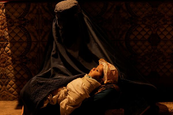 زن افغان با چهره پوشیده و کودکی در آغوش  - اسپوتنیک ایران  