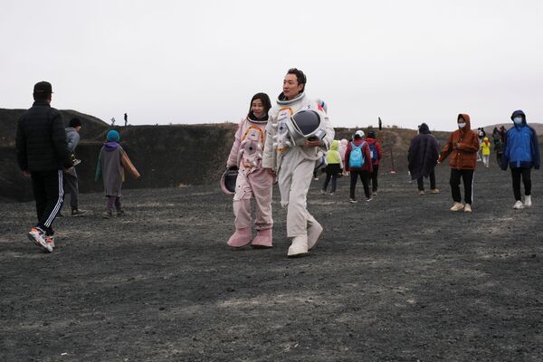 بازدیدکنندگان آتشفشان شماره 6 از گروه آتشفشان های Ulan Had در چین.  - اسپوتنیک ایران  