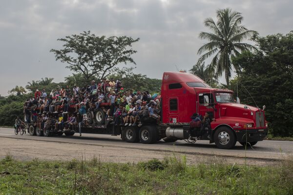 مهاجران سوار بر تریلی در حال حرکت بسوی مرز مکزیک و آمریکا - اسپوتنیک ایران  