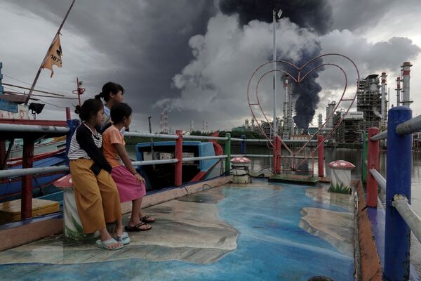 بچه ها محو تماشای دود بلند شده از آتش سوزی در کارخانه ای در جاوا، اندونزی. - اسپوتنیک ایران  
