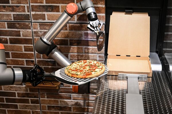 ربات هایی که در سال 2021 با ما بودند.ربات آشپز در حال درست کردن پیتزا در رستورانی در پاریس. - اسپوتنیک ایران  