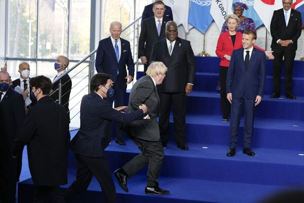 مهمترین رویدادهای سیاسی سال 2021 میلادی.گروه جی 20. کمک به بوریس جانسون برای بالا رفتن از پله و قیافه خندان مکرون، رئیس جمهور فرانسه. - اسپوتنیک ایران  