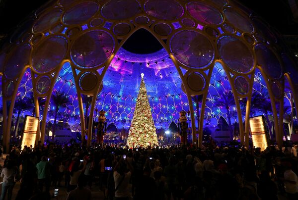 تماشاچیان  حاضر در مراسم روشن شدن چراغ های درخت کریسمس در گنبد الوصل در اکسپو 2020 در دبی. - اسپوتنیک ایران  