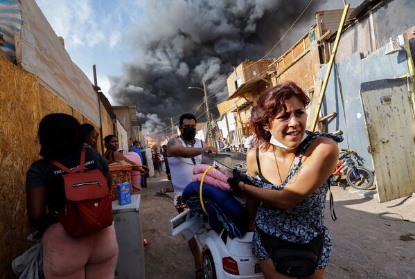 ساکنان خانه های سوخته در حال نجات فرار و نجات وسایل خود در شمال شیلی. - اسپوتنیک ایران  