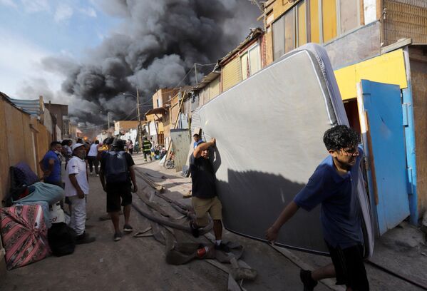 ساکنان خانه های سوخته در حال نجات فرار و نجات وسایل خود در شمال شیلی. - اسپوتنیک ایران  