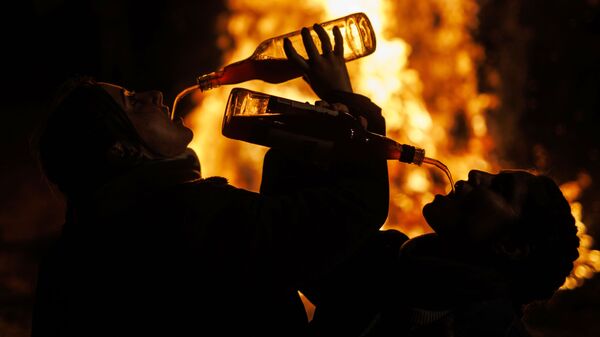 Люди пьют вино около костра во время традиционного праздника Люминариас в деревне Сан-Бартоломей де Пинаре в Испании - اسپوتنیک ایران  