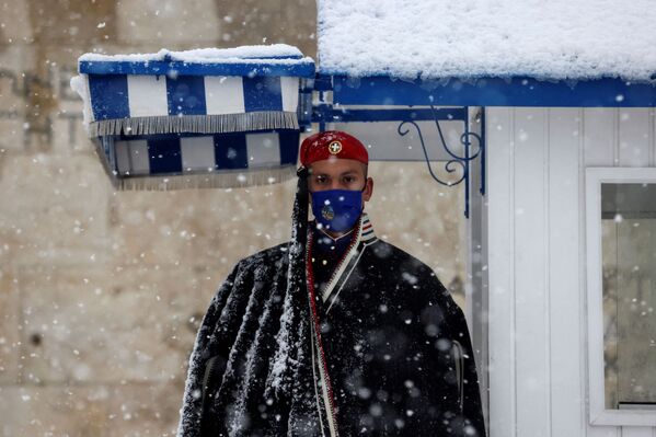 یک گارد ریاست جمهوری یونان وظیفه نگهبانی خود را در مقبره سرباز ناشناس در بارش شدید برف در آتن یونان، ۲۴ ژانویه ۲۰۲۲ انجام می دهد. - اسپوتنیک ایران  