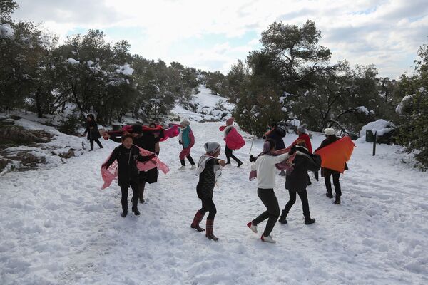 چینی های ساکن یونان در پی بارش شدید برف در آتن یونان، ۲۵ ژانویه ۲۰۲۲ بر روی برف تپه فیلوپاپو می رقصند. - اسپوتنیک ایران  