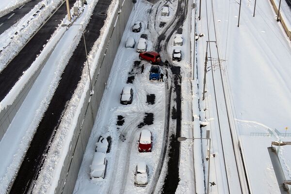 آتش نشانان برف اطراف یک ماشین را کنار می زنند در حالی که وسایل نقلیه رها شده در بزرگراه آتیکی اودوس زیر برف پوشیده شده اند، به دنبال بارش برف سنگین در آتن، یونان، 25 ژانویه 2022. تصویر با پهپاد گرفته شده است. - اسپوتنیک ایران  
